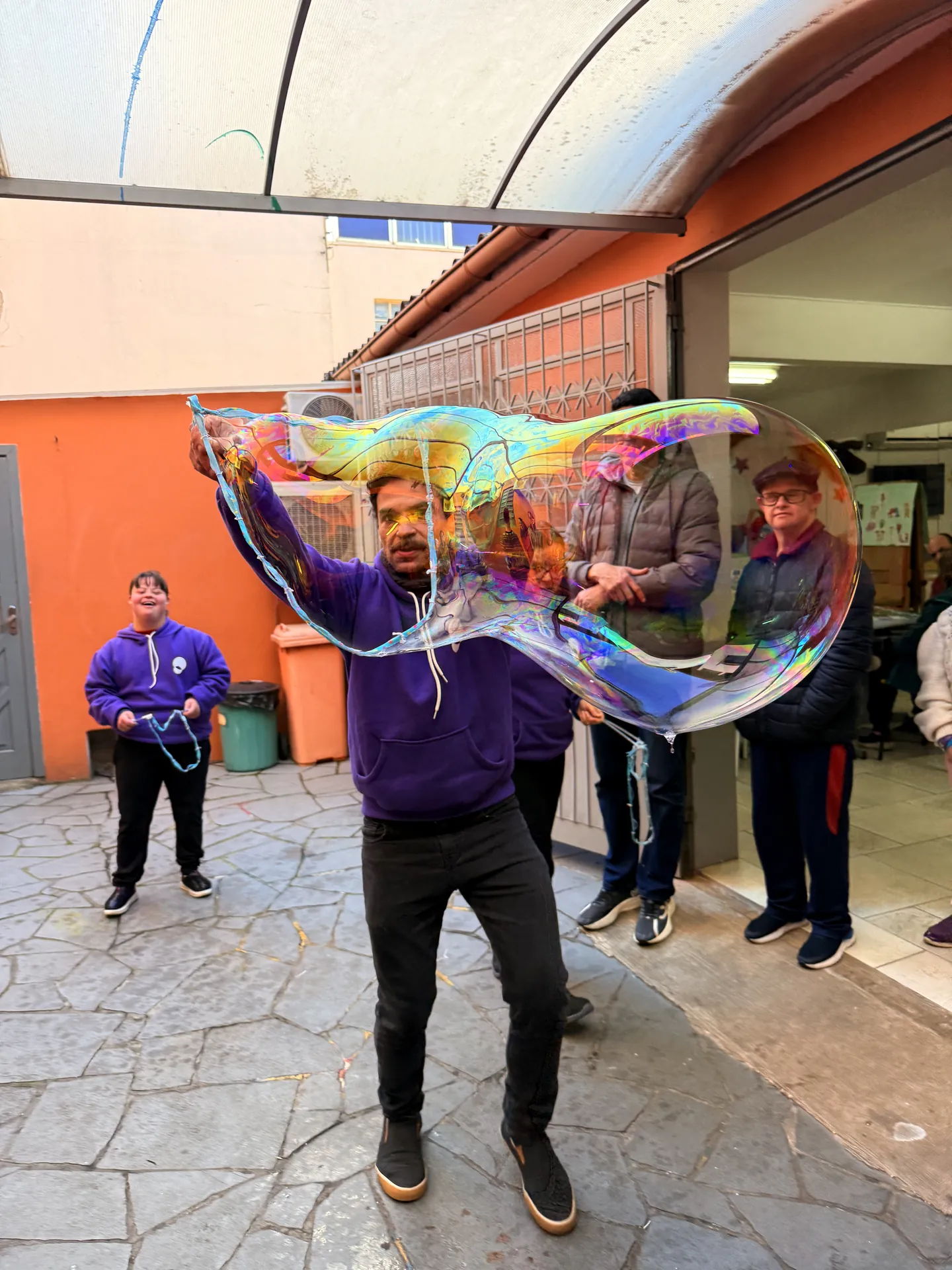 Participante faz uma bolha de sabão gigante em atividade ao ar livre.