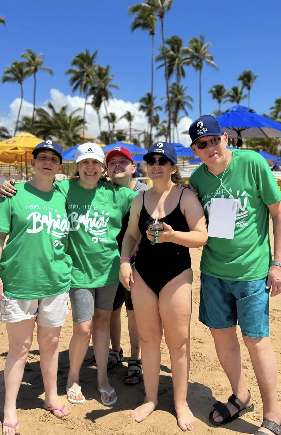 Participantes de camiseta da viagem posam na praia, na Bahia.
