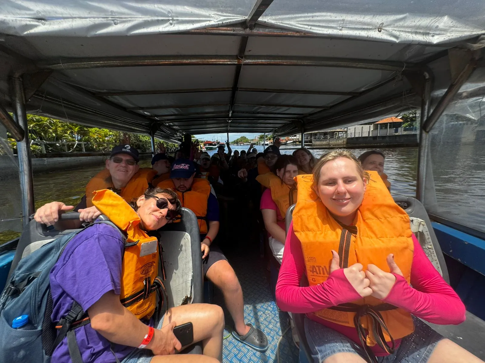Participantes de colete salva-vidas durante um passeio de barco.