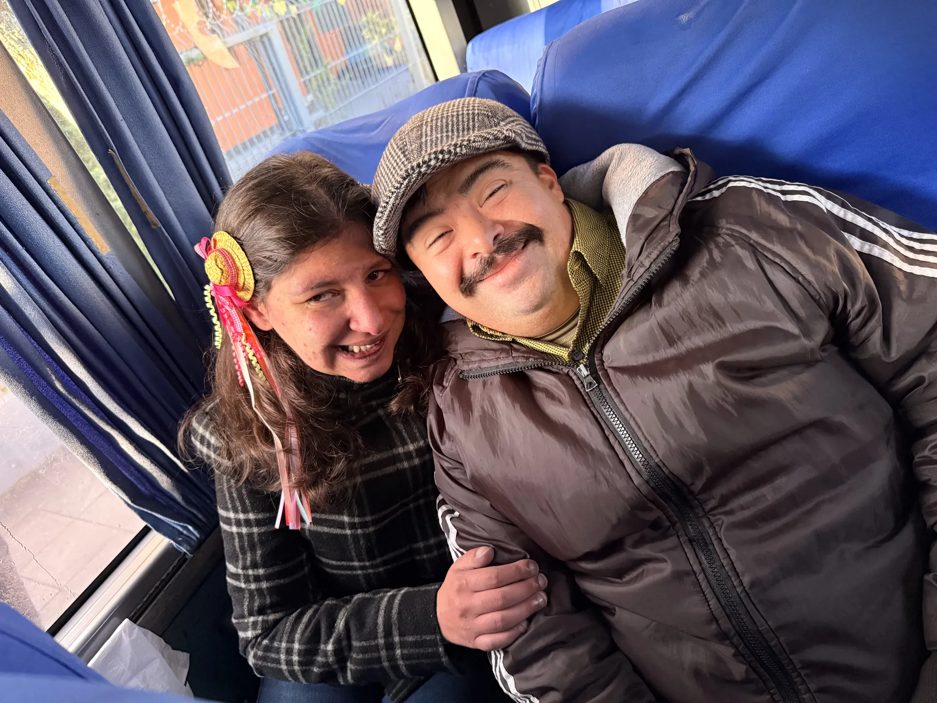 Dupla abraçada no ônibus, a caminho do passeio.