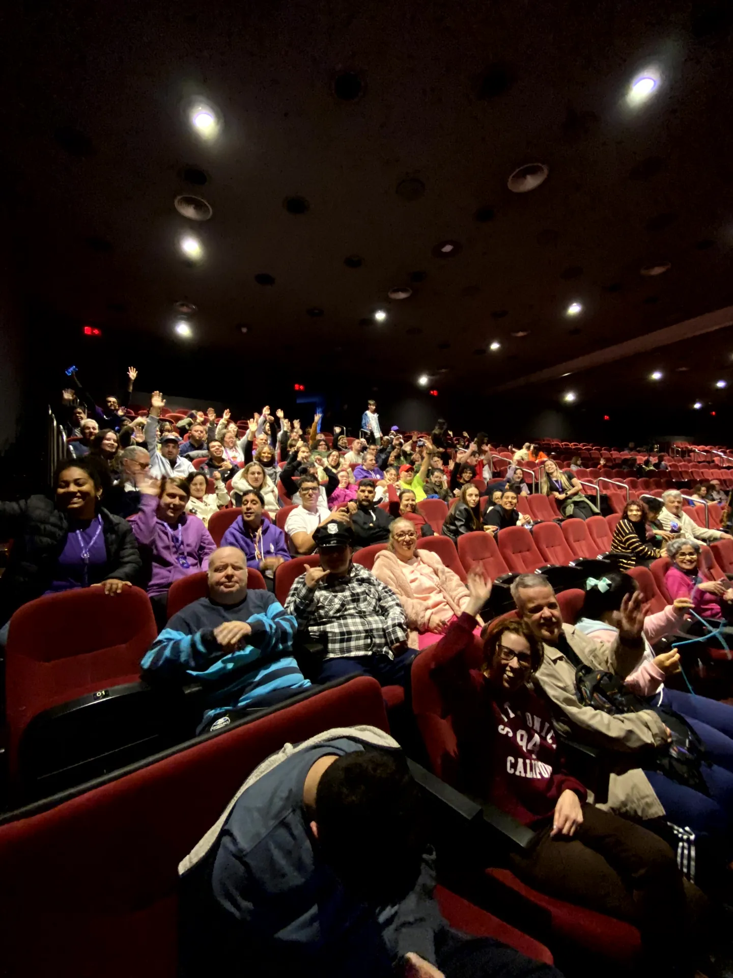 Participantes do Pertence sentados na plateia de uma sala de cinema.
