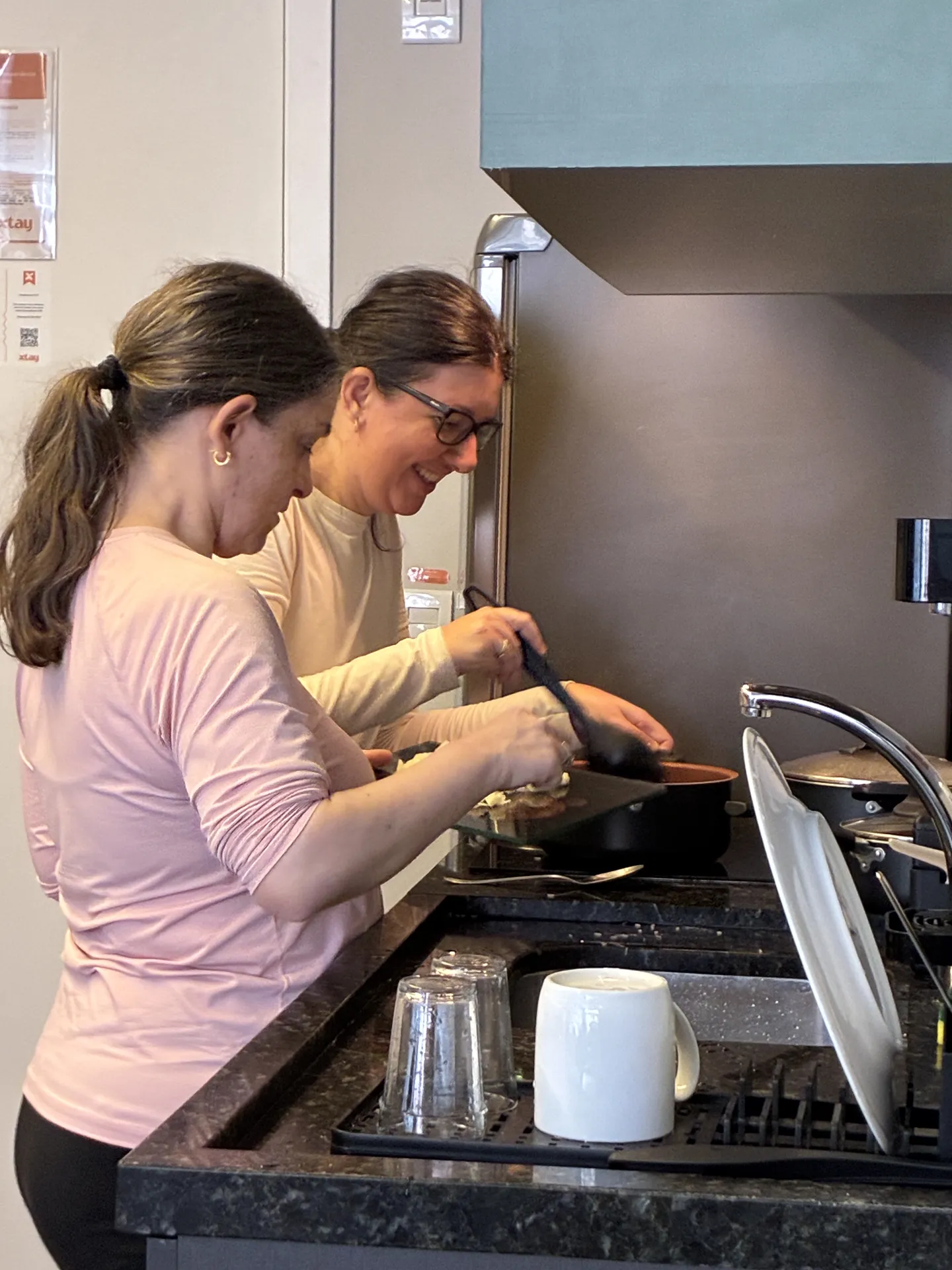 Participante cozinha no fogão com o apoio de uma educadora.