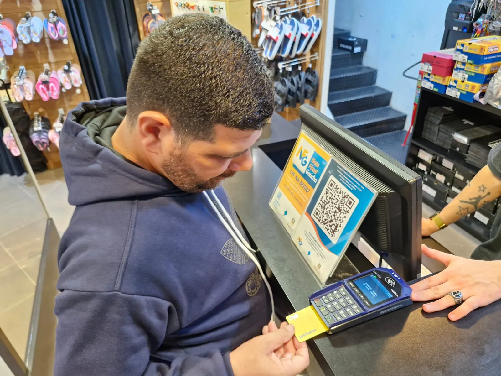 Participante paga a compra na maquininha do caixa.
