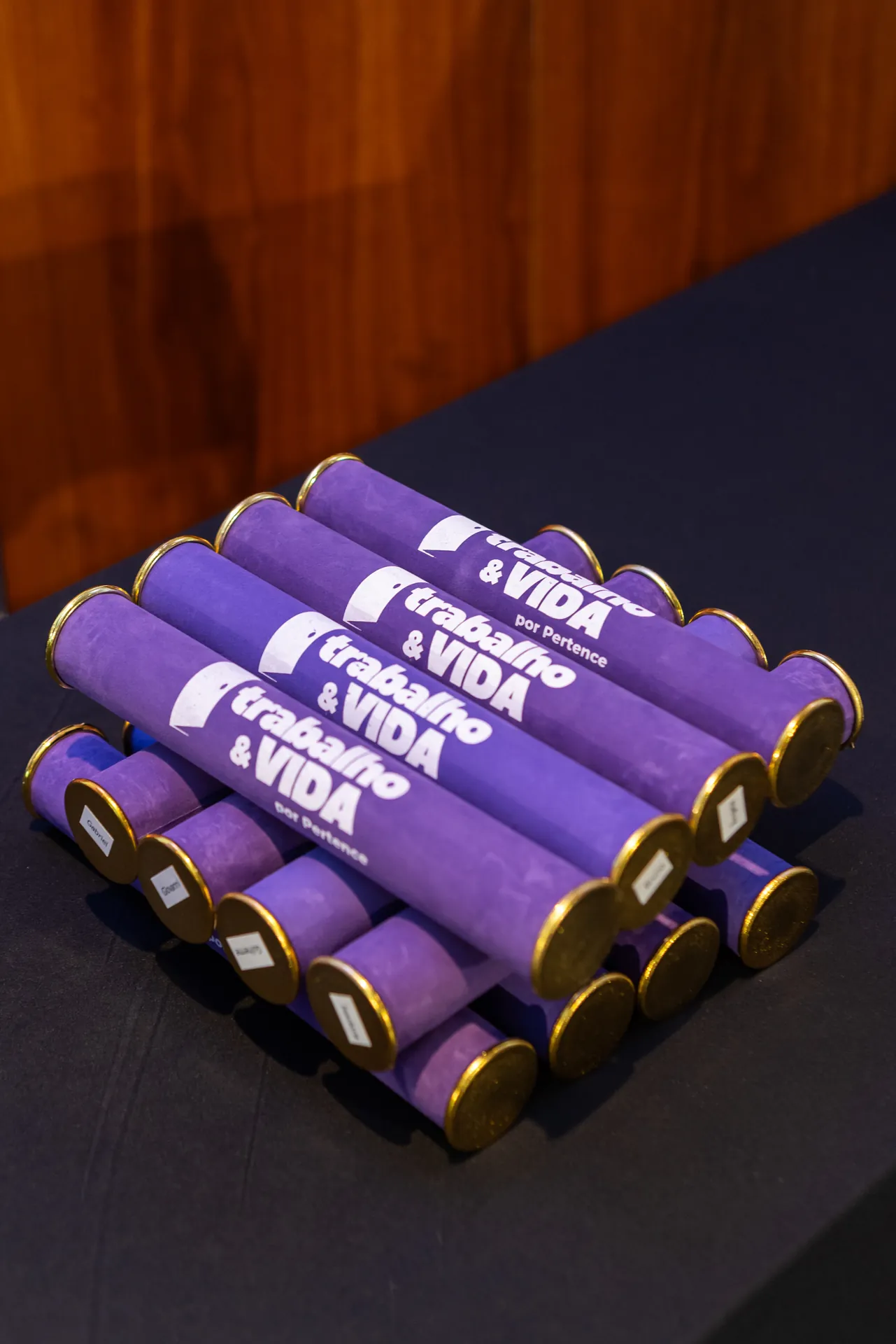Canudos de formatura do Trabalho & Vida empilhados sobre a mesa.