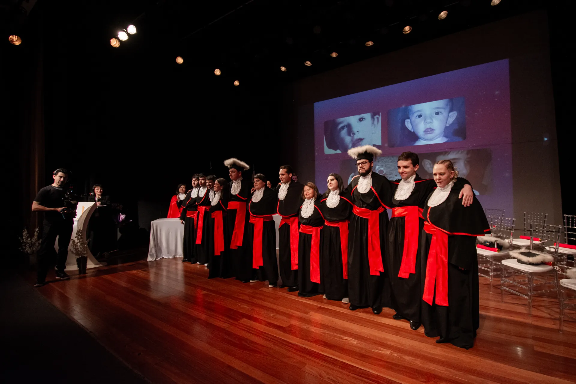 Formandos enfileirados no palco durante a colação de grau.
