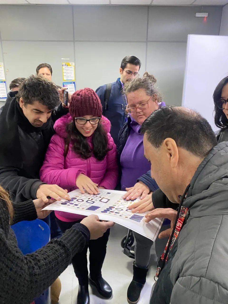 Participante e equipe do Pertence analisam juntos um material impresso.