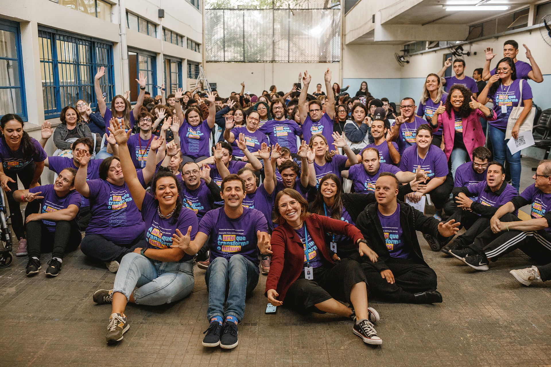 Turma do Clube Social Pertence reunida, com as mãos para o alto.
