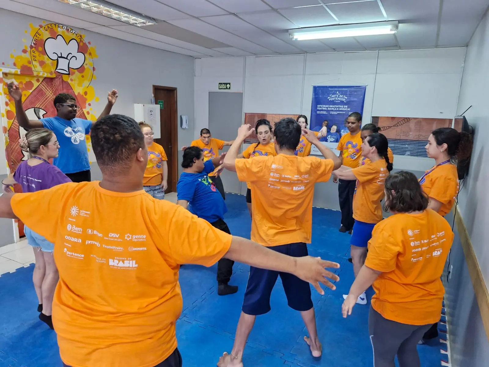 Participantes de braços abertos durante o aquecimento em grupo.