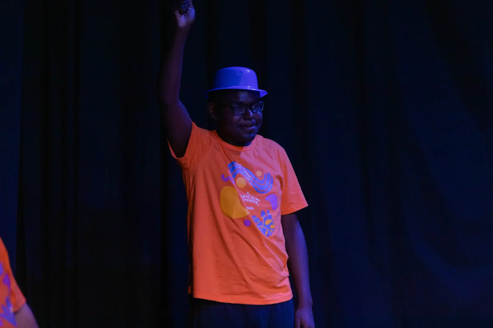 Participante com o braço erguido durante a apresentação.
