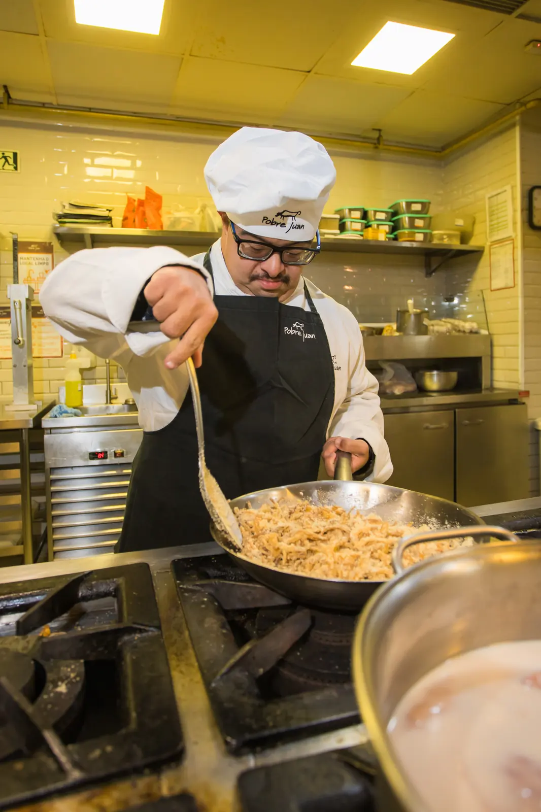 Participante finaliza um prato na cozinha do restaurante parceiro.