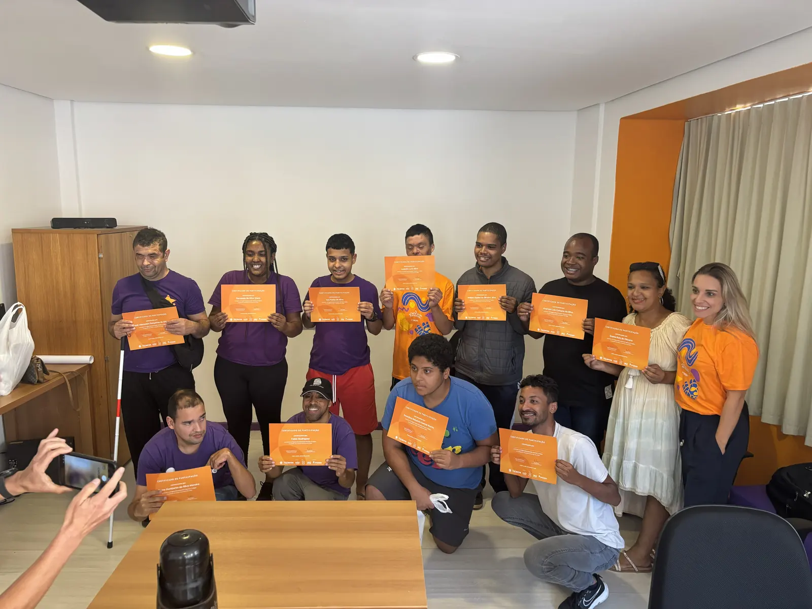 Participantes exibem os certificados de participação do Desenvolvendo Talentos ao lado da equipe do Pertence.