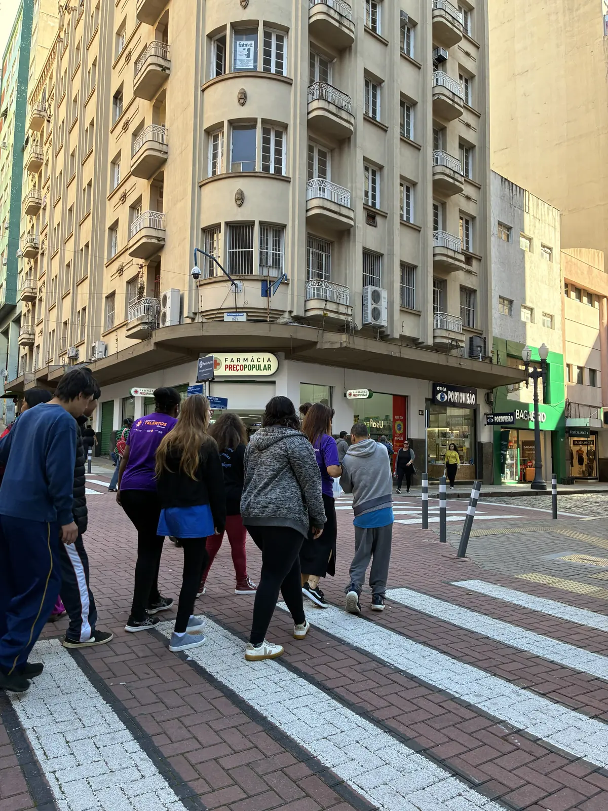 Grupo de participantes atravessa uma faixa de pedestres no centro de Porto Alegre, a caminho de uma visita técnica.
