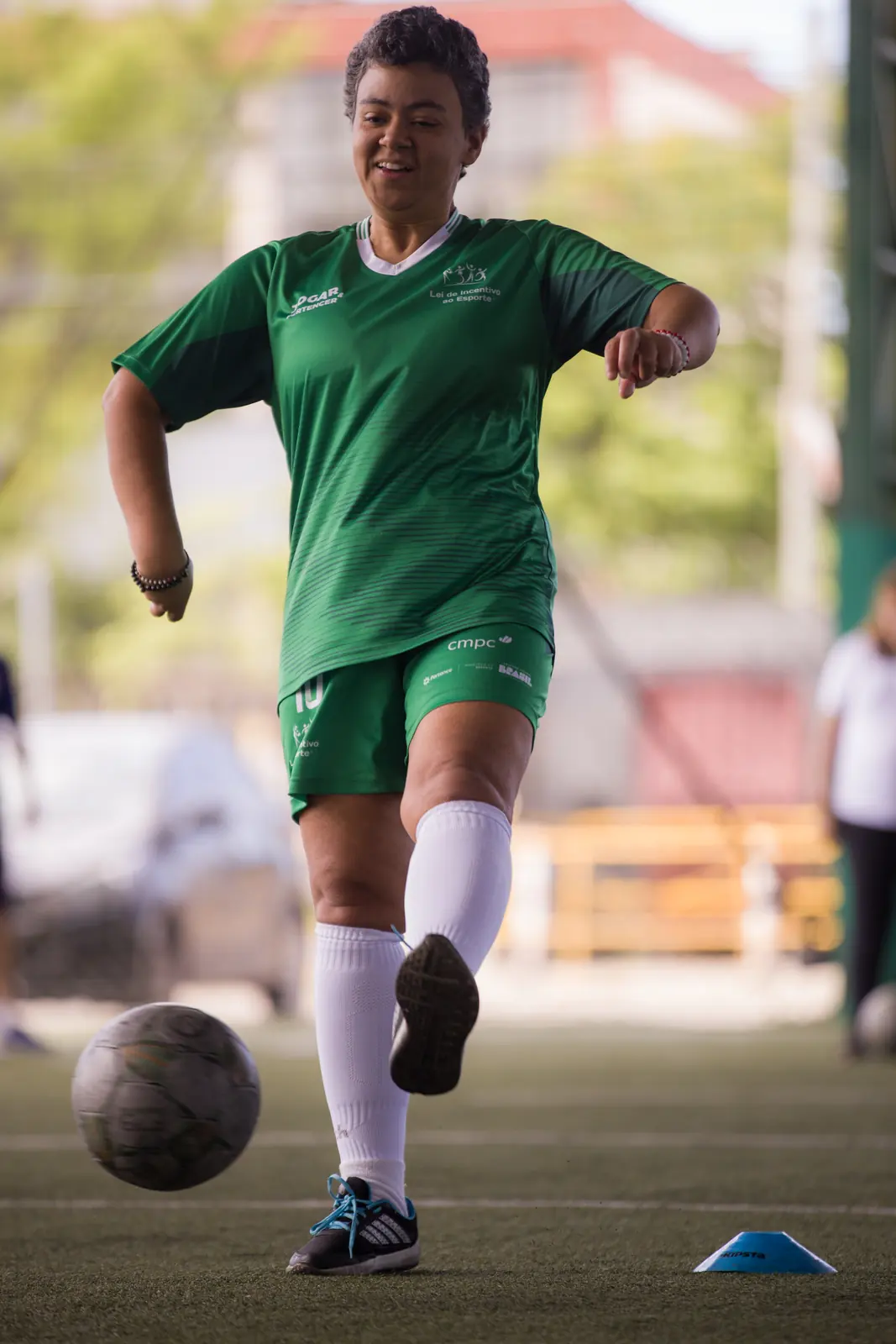 Jogador em movimento, conduzindo a bola pelo campo.