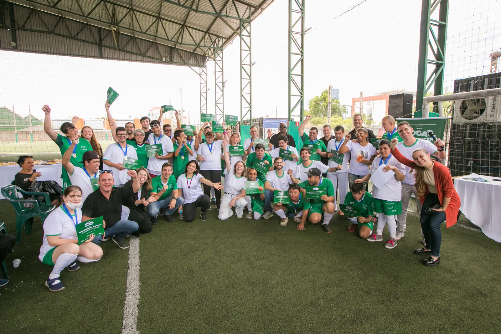 Time reunido no campo para a foto oficial, com equipe técnica e famílias.